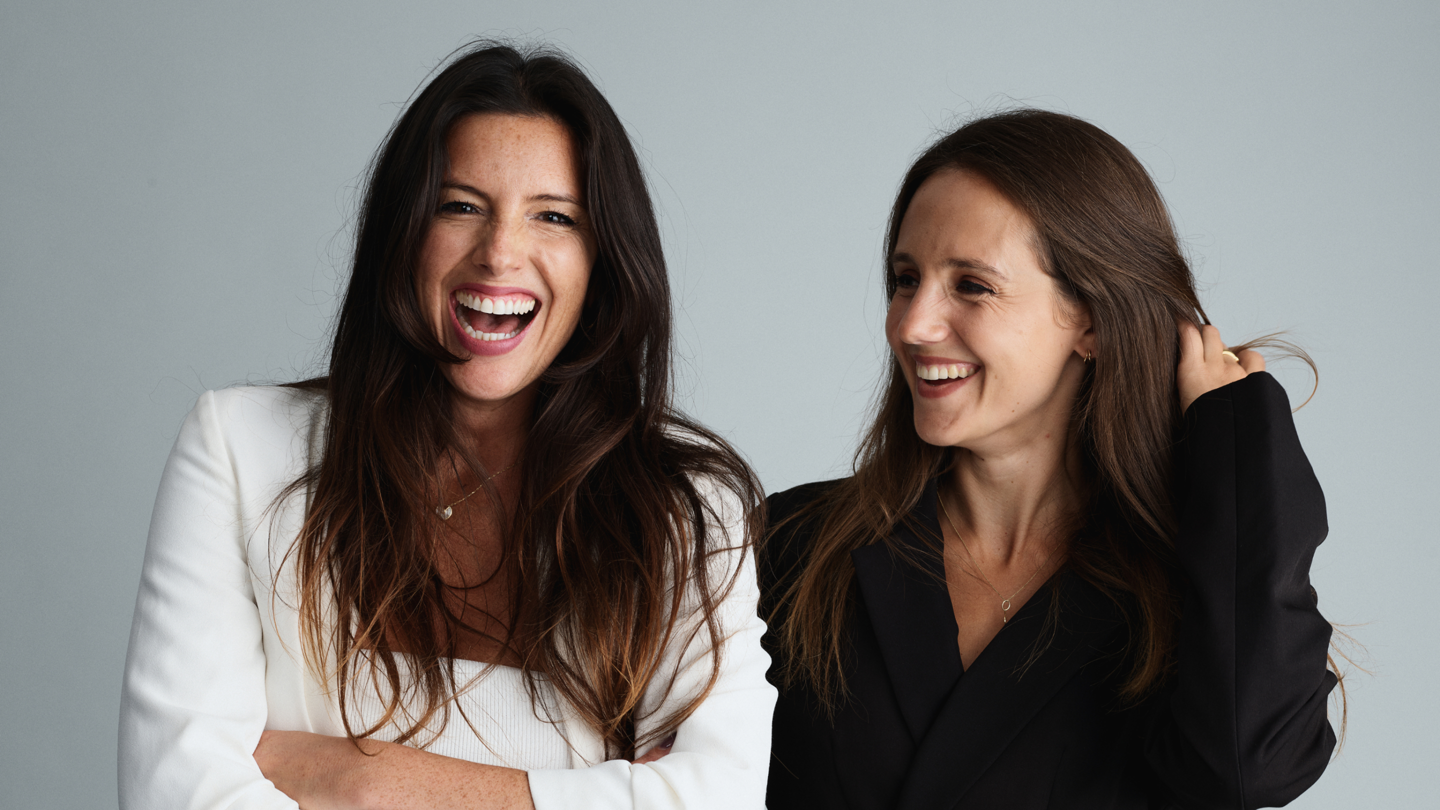 Two lead women of Truffle social stood next to each other laughing.
