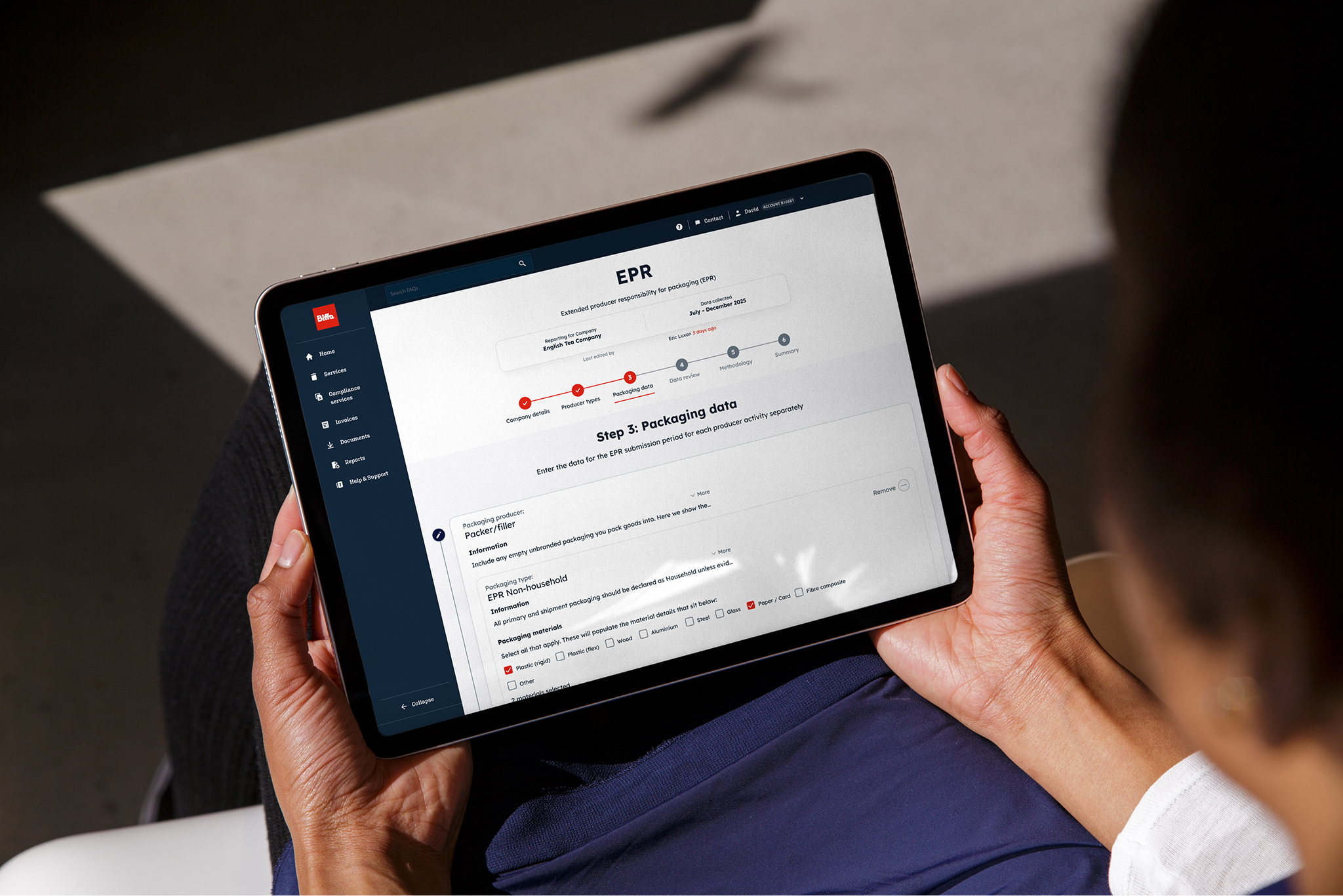 A tablet in a mans hand showing the Biffa platform