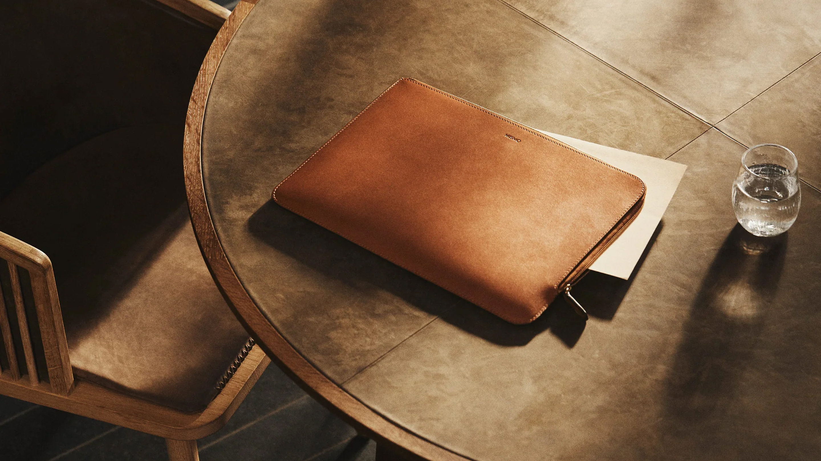 A leather laptop case on a table.