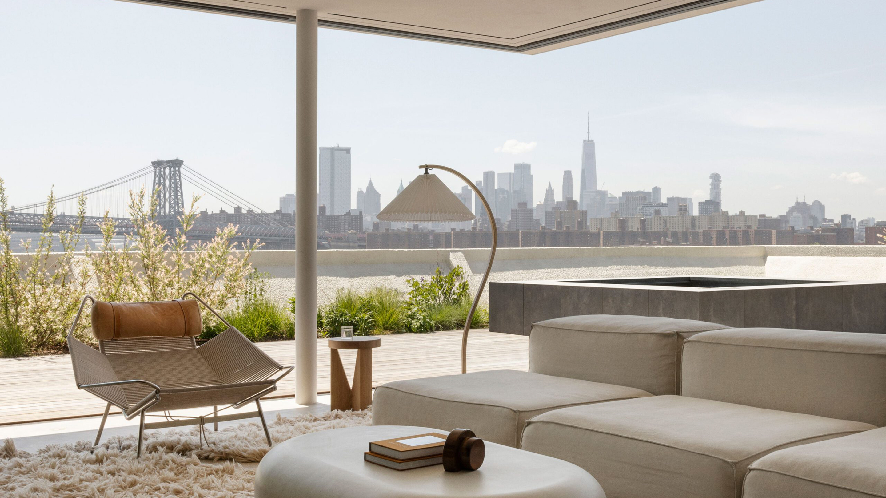 A stylised photograph of a interior design living room showing New York in the background. 